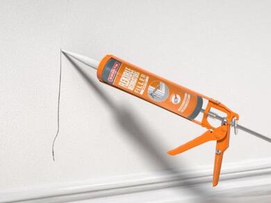 Applying EVO-STIK Flexible Decorators Filler to a wall crack above a skirting board for a smooth paintable finish
