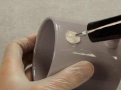 Applying repair adhesive to a chipped ceramic mug using a precision applicator for a durable repair