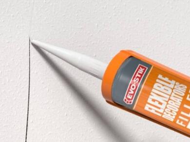 Applying decorators caulk along a wall joint to fill gaps and create a smooth surface before painting.